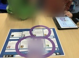 Drei Schüler:innen markieren passende Internetseiten zum Thema "Fuchs" und dokumentieren ihre Ergebnisse im iPad.