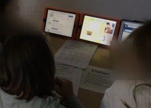 Drei Schüler:innen vergleichen auf drei Tablets verschiedene Suchmaschinen.