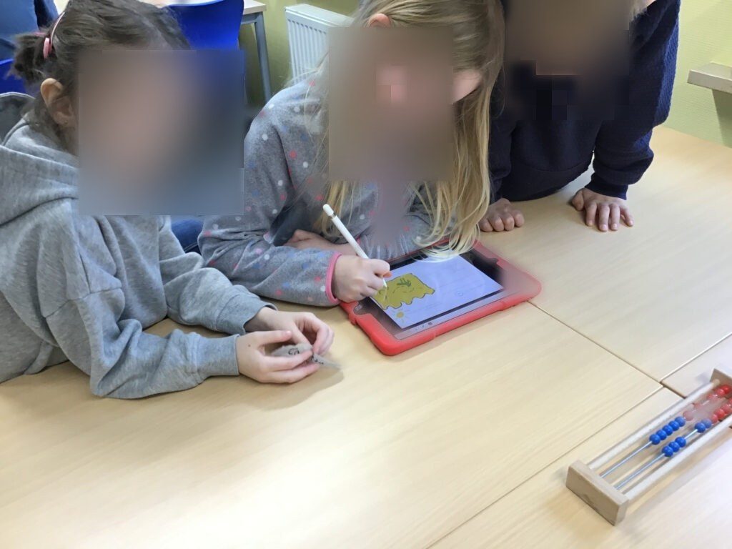 Drei Kinder malen für den Steckbrief den Lebensraum ihres Tieres.