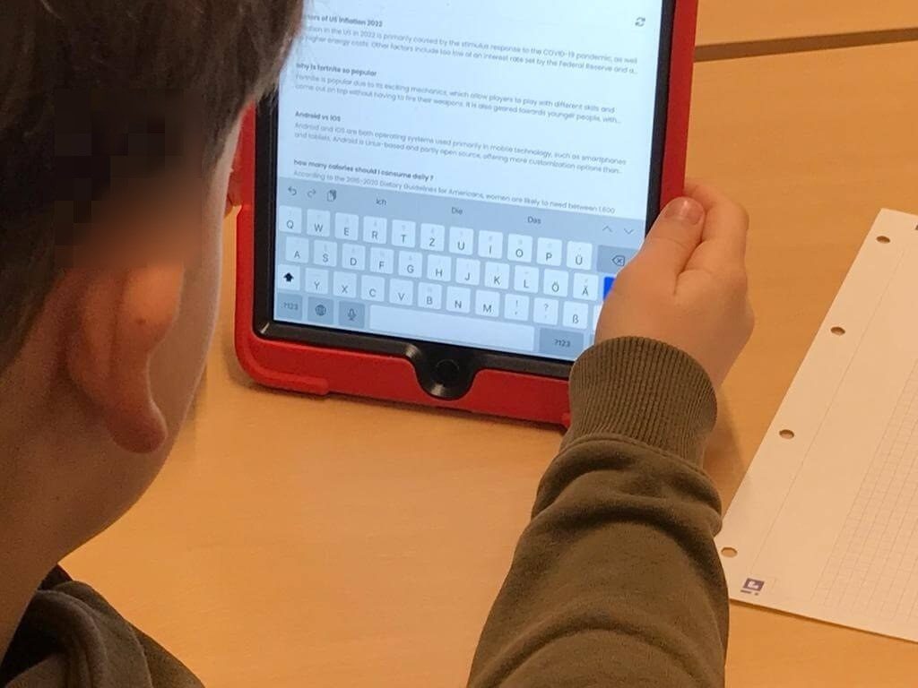 Schüler ließt auf dem Tablet informationen mit Hilfe der künstlichen Intelligenz.