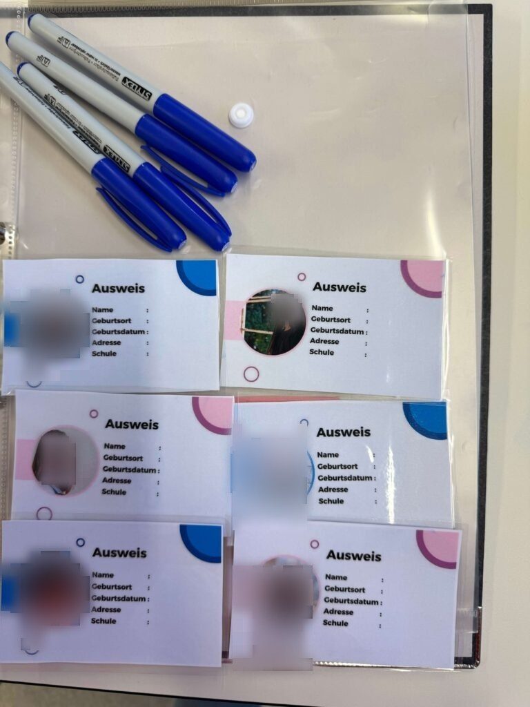 In dem schwarzen Ordner liegen die sechs ausgedruckten und laminierten Ausweise, sowie Folienstifte.