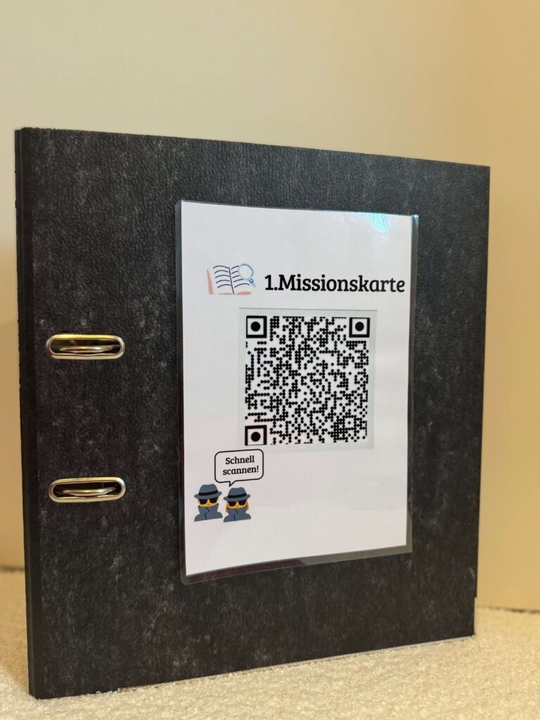 Der schwarze Ordner mit der aufgeklebten Missionskarte als QR-Code