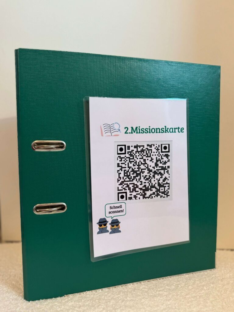 Der grüne Ordner mit der aufgeklebten Missionskarte als QR-Code