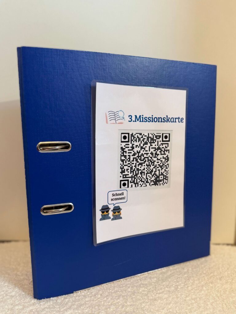 Der blaue Ordner mit der aufgeklebten Missionskarte als QR-Code