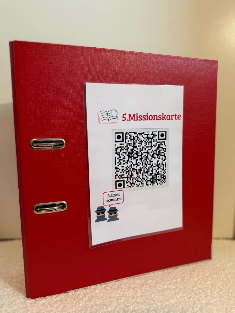 Der rote Ordner mit der aufgeklebten Missionskarte als QR-Code