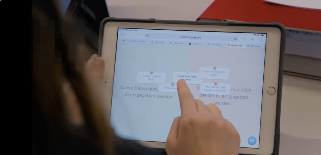 Eine Schülerin arbeitet an ihrem iPad in der LearningApp und schiebt die verschiedenen Informationsarten in die Kategorien "Diese Daten dürfen bei der KI angegeben werden" und "Diese Daten dürfen nicht bei der KI angegeben werden".