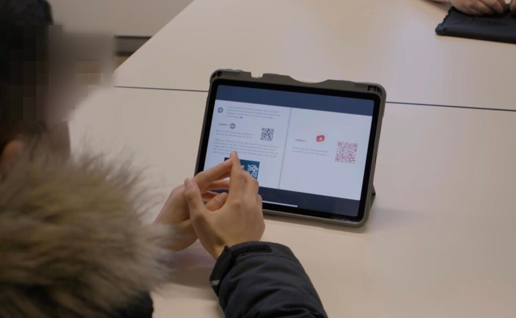 Ein Schüler liest sich auf seinem iPad die Aufgabenstellung im Book Creator durch.