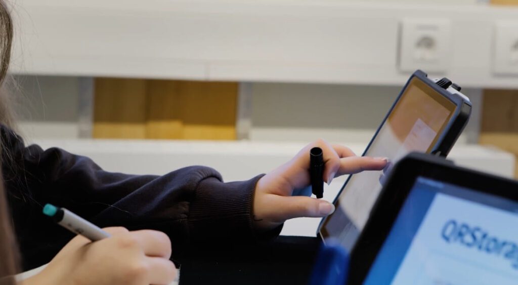 Eine Schülerin tippt gerade auf den Book Creator, um sich die Aufgabenstellung anzuhören.